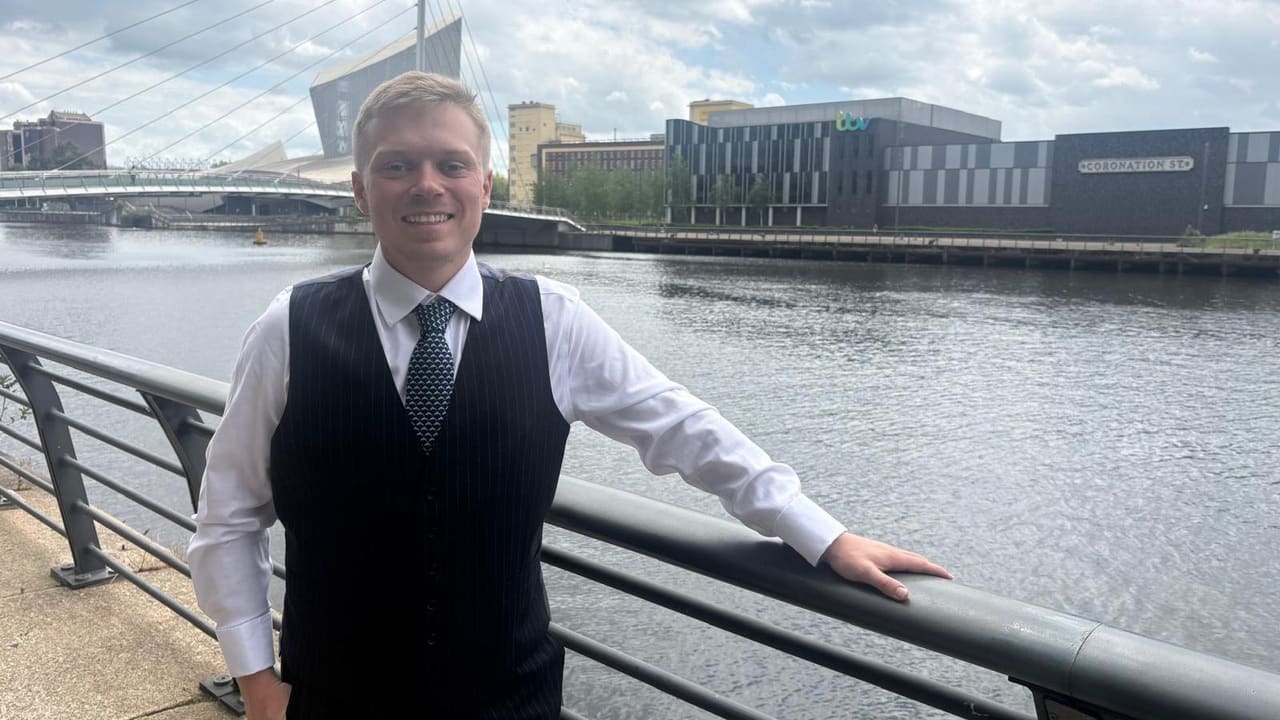 George Isaacs, accountant, at Salford Quays with MediaCityUK behind him